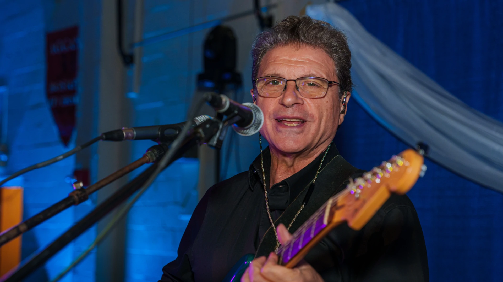 Stelios Karaminas on guitar with Orfeas Band mid-performance
